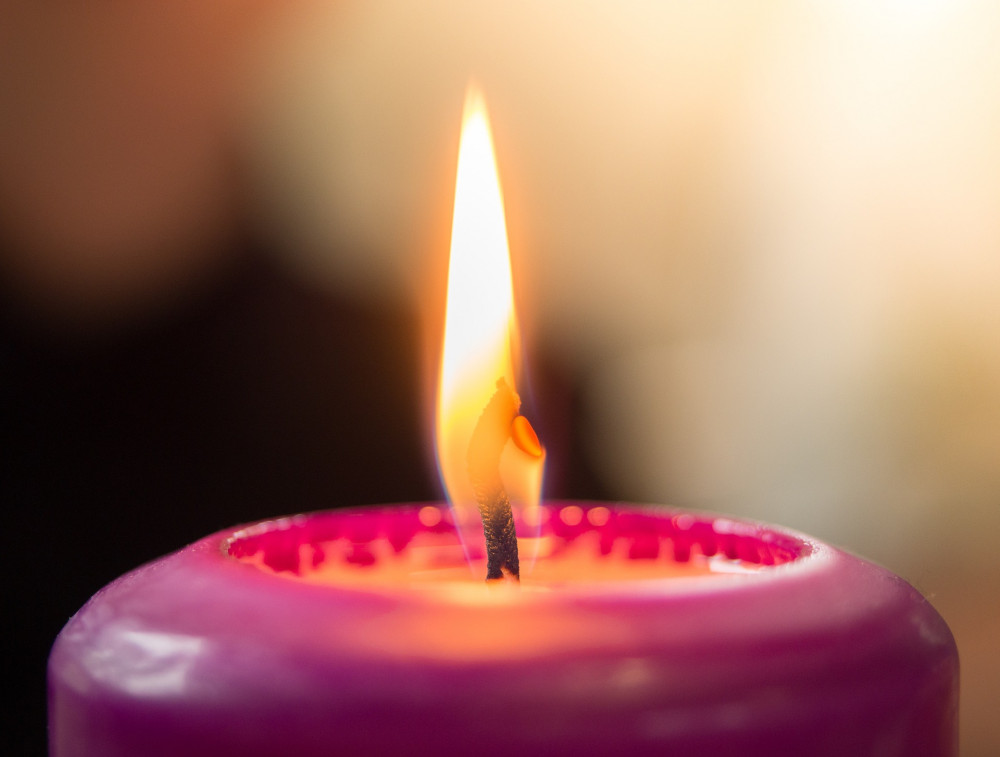 A photo of a lit pink candle